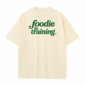 “foodie in training” Cream T-Shirt